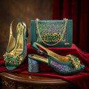 Teal high-heeled shoes with gemstone embellishments and a matching handbag on a red fabric background, Obroi