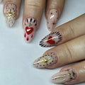 Nails with decorative designs including hearts and stars on a light background, Obroi