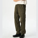 Person wearing olive green cargo pants on a white background, Obroi