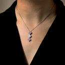 Necklace with pink and white gemstones on a person wearing a black top.