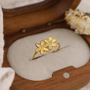 Gold flower-shaped bracelet on a wooden stand with a neutral background, Obroi