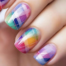 Colorful plaid nail design on a hand with a blurred background, Obroi