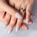 Close-up of hands with light blue nail polish and star designs on a neutral background, Obroi