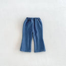 A pair of blue denim cropped pants with an elastic waistband, laid flat on a light textured background, Obroi