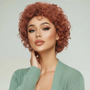 Woman with styled red hair wearing a green sweater against a light background, Obroi