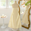 Beige dress on a mannequin in front of a decorative mirror with floral decorations, Obroi