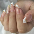 Close-up of a hand with white and gold nail polish on a neutral background, Obroi