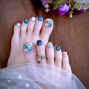  toes with decorative nail art and rings on a neutral background, Obroi