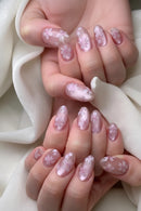 Close-up of a hand with pink floral nail design on a soft background, Obroi