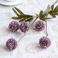 Purple flowers and green leaves on a lace tablecloth, Obroi