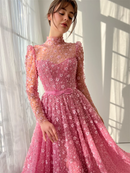 Woman wearing a pink dress with floral details in a softly lit room, Obroi