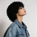 Woman with curly hair wearing a denim jacket against a plain background, Obroi