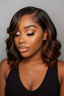 A wavy wig with dark brown and warm auburn highlights, shown on a model from the front and on a mannequin head from the back and side against a plain gray background, Obroi