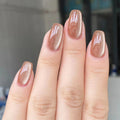 Close-up of a hand with nude nail polish on a blurred background, Obroi