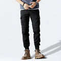 Person wearing black cargo pants and brown boots on a white background, Obroi