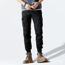 Person wearing black cargo pants and brown boots on a white background, Obroi