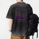 Person wearing a black t-shirt with motivational text on the back, carrying a black backpack, Obroi
