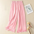Pink pants with lace trim on a beige surface with a photo frame and shoes, Obroi