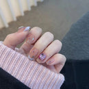 Close-up of a hand with decorative nails wearing a pink sweater, Obroi