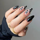 Hand with black and white floral nail design on a neutral background, Obroi