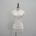 White short-sleeve t-shirt with black polka dots displayed on a cream dress form mannequin against a light gray background, Obroi