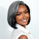 A smiling woman wearing a short, layered bob wig with gray and black ombre styling, paired with a white collared shirt against a clean light gray background, Obroi