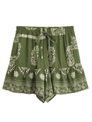 Green shorts with white floral patterns on a white background, Obroi