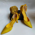 Yellow high-heeled shoes with decorative elements on a white background, Obroi