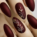 Nails with dark brown polish and white leaf designs on a neutral background, Obroi