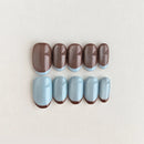 Set of handmade nails with a slight difference in color and shape on a light background, Obroi