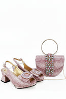 Pink high-heeled shoes with embellishments and a matching handbag on a white background, Obroi