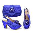 A matching royal blue embellished women's set featuring a clutch bag, slingback high-heel sandals, and open-toe heels, all decorated with sequins, beads, and flower appliques with pearl centers, shown on a white background, Obroi