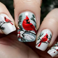 Nail art with red cardinals and winter elements on a white background, Obroi