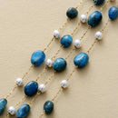 Necklace with blue beads and gold chain on a beige background, Obroi