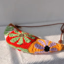 Colorful crocheted bag with floral patterns on a white surface, Obroi