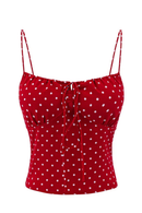 Red camisole top with white polka dots and thin shoulder straps, featuring a front tie closure, shown on a plain white background, Obroi