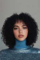 Woman with curly hair wearing a blue turtleneck and sparkly top against a gray background, Obroi