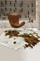 Hexagonal cowhide rug with a modern chair in a stylish room, Obroi