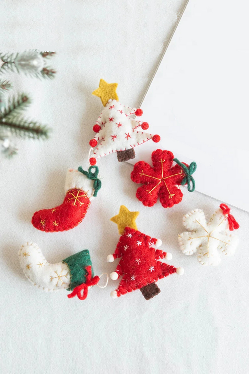 Set of Christmas-themed felt ornaments on a white , Obroi