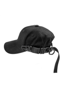 A black baseball cap with an adjustable black chin strap and buckle closure, shown from a side profile on a solid white background, Obroi