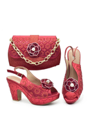 A coordinated women's accessory set in bright pink-red fabric, including a handbag with a gold chain strap, a heeled sandal, and a slingback mule, all decorated with floral applique and pearl-like center details on a white background, Obroi