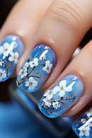 Nails with blue nail polish and white floral design, Obroi