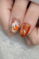 Nail art with a gold leaf design on a textured surface, Obroi