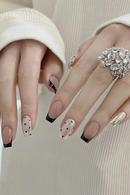 Close-up of hands with decorative nail art and a ring on a neutral background, Obroi