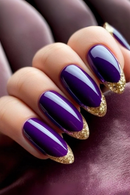 Close-up of a hand with purple nails and gold tips on a dark background, Obroi