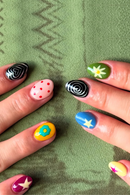 Colorful nail art on a green textured fabric background, Obroi