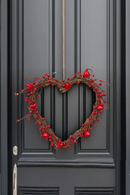 Heart-shaped wreath with red berries on a dark gray door, Obroi