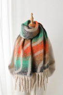 Colorful striped scarf with fringes on a wooden hanger against a white background, Obroi