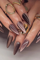 Close-up of hands with dark nail polish and gold rings on a neutral background, Obroi