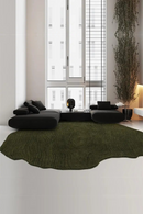 Modern living room with a green rug, black sofa, and large windows, Obroi